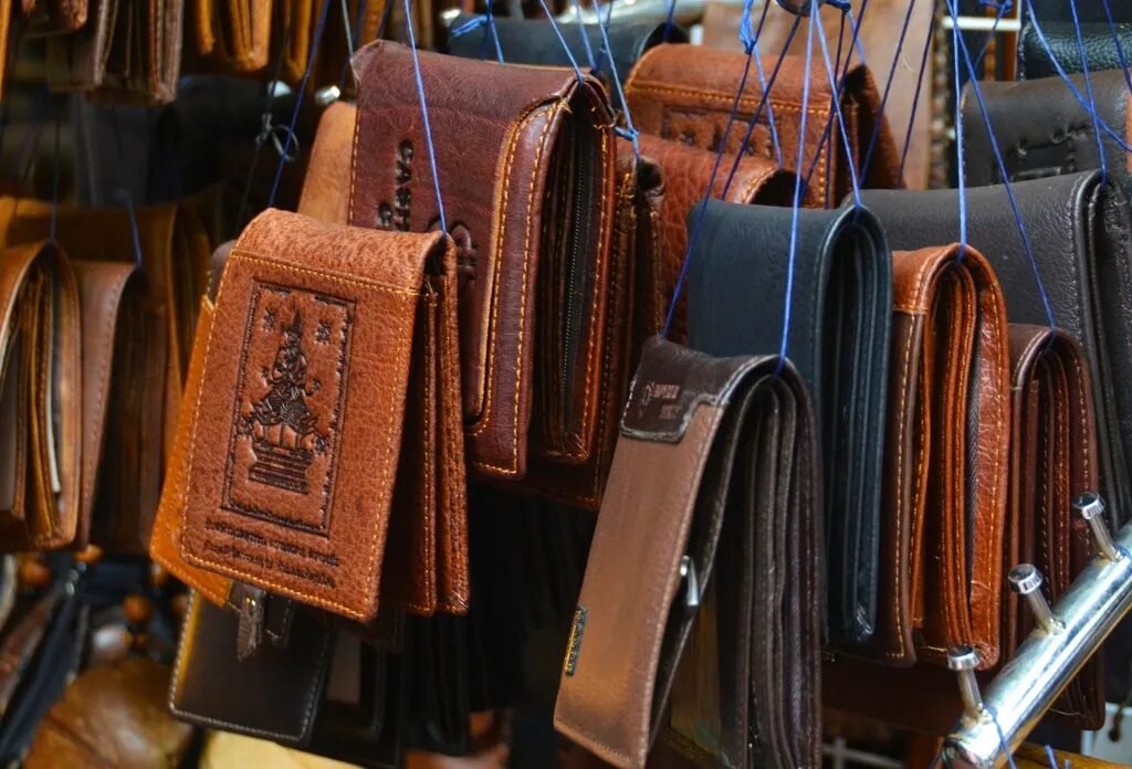 Những chiếc ví da bò màu nâu và đen treo trên giá